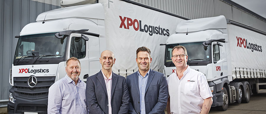 Representantes de XPO Logistics y Mercedes Benz delante de los camiones