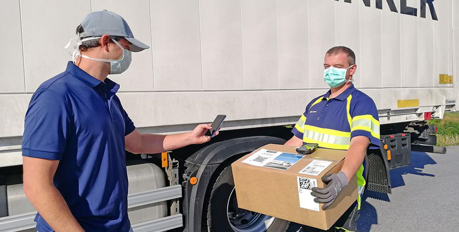 Dos operarios de logística manejan un paquete